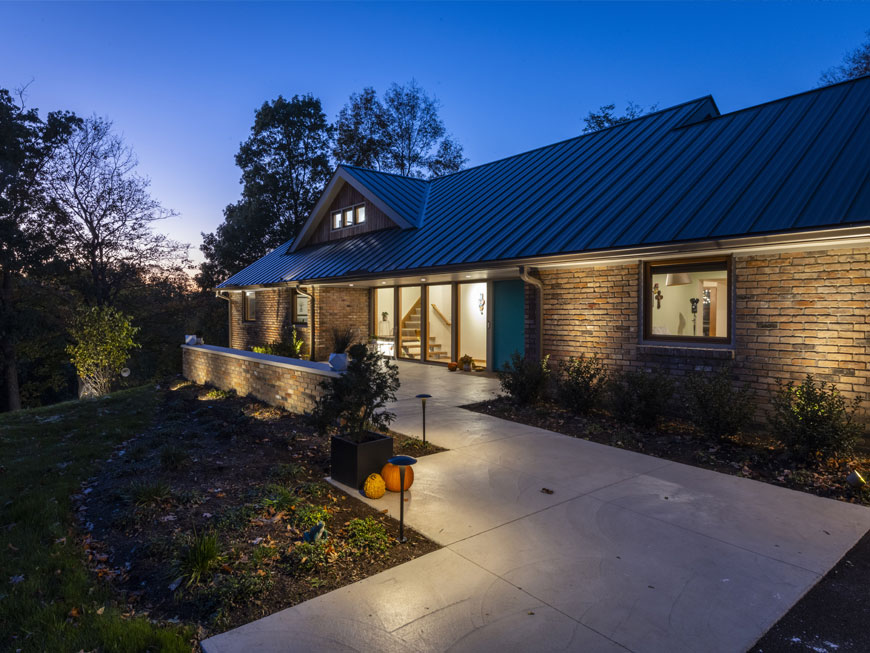 Back face of mid-century modern home remodel by Chris Kepes, photo is a night scene with interior lit up